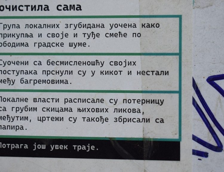 Text on a weathered wall with blue and white stripes.